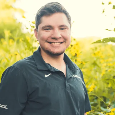Jordan Evans standing before field of yellow flowers